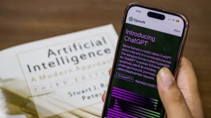 Phone displaying ChatGPT beside an AI book