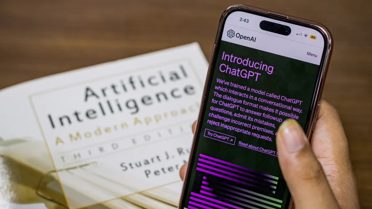 Phone displaying ChatGPT beside an AI book