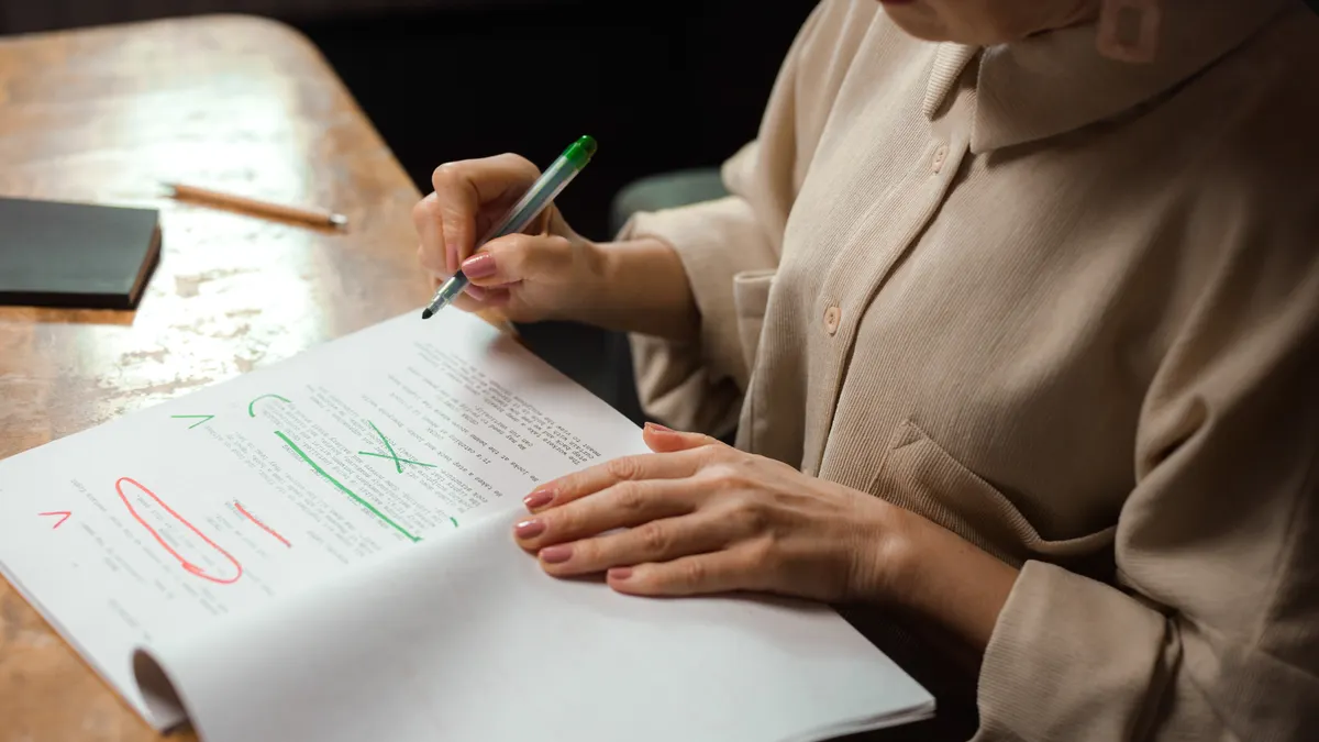 person editing a document with notes and highlights