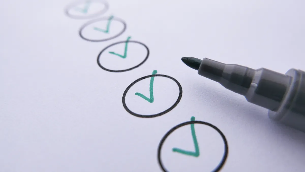 checkmarks on paper being marked with a pen