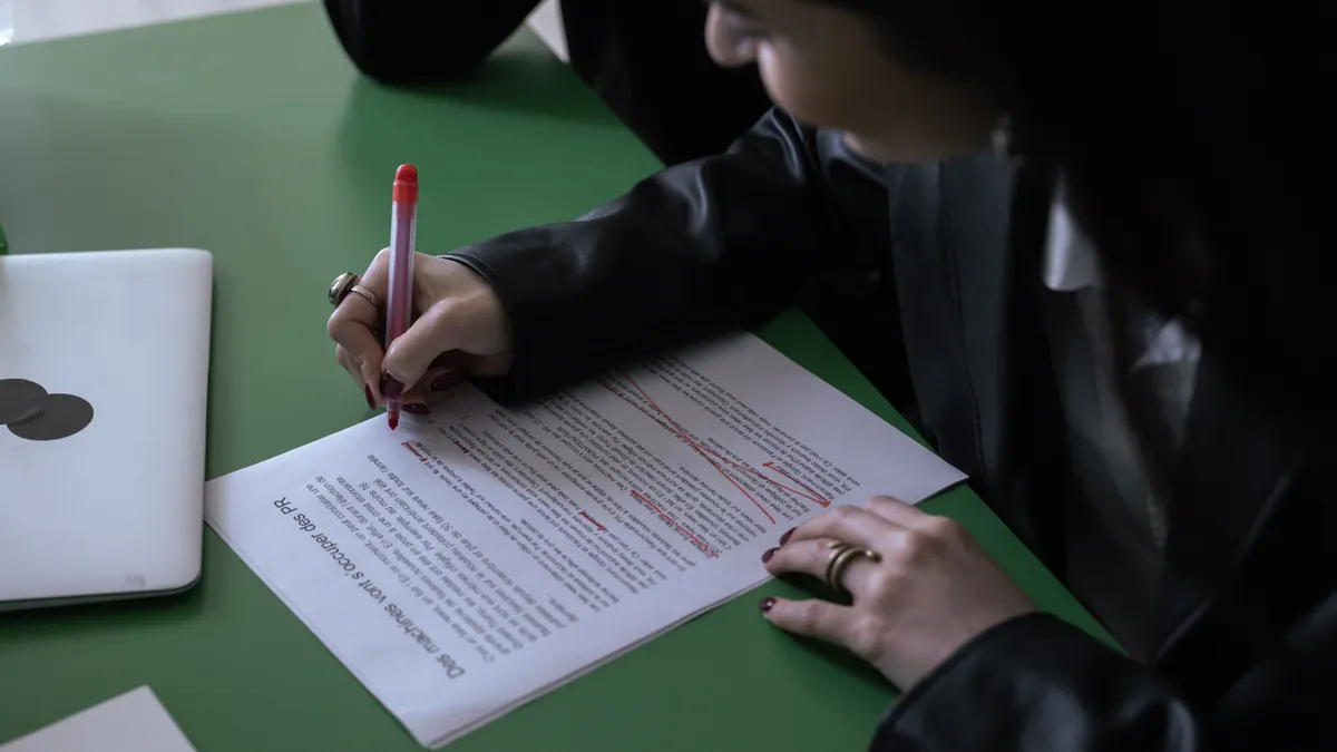 person editing a printed article on a desk