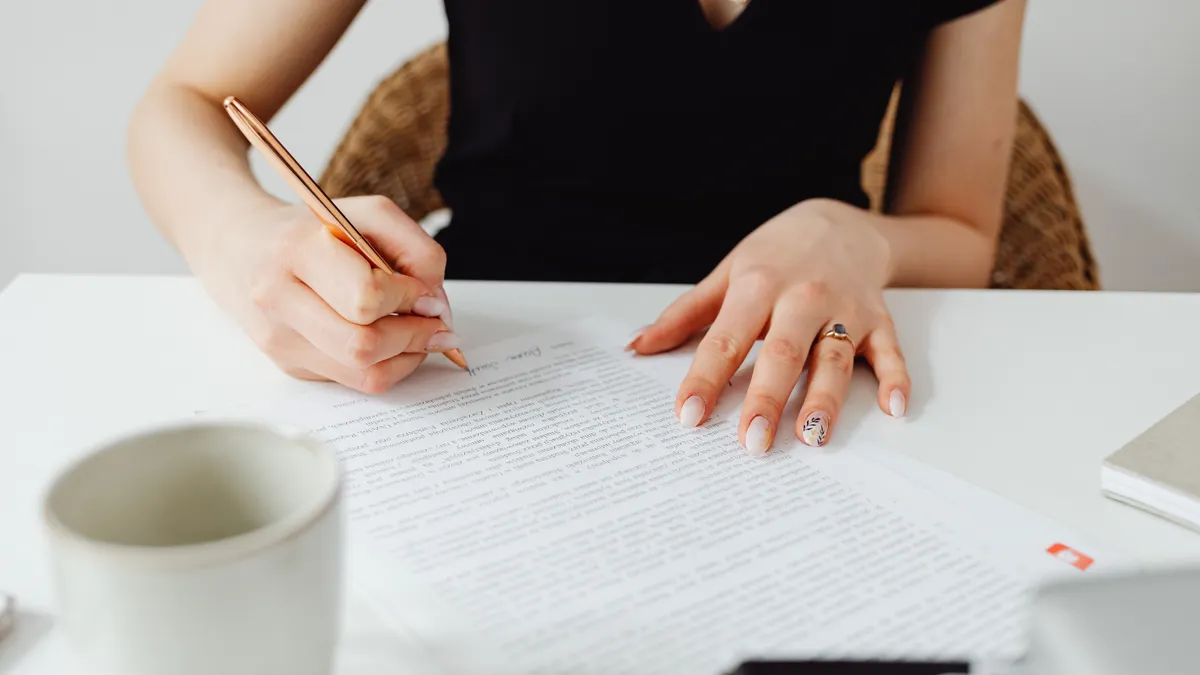 person proofreading a printed draft with a pencil